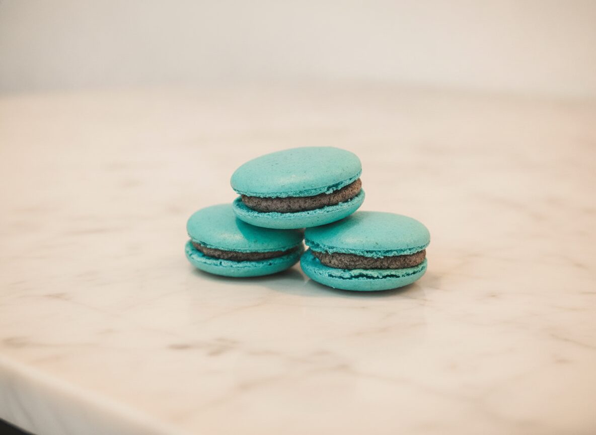 Row of French macarons resting on Carrara marble